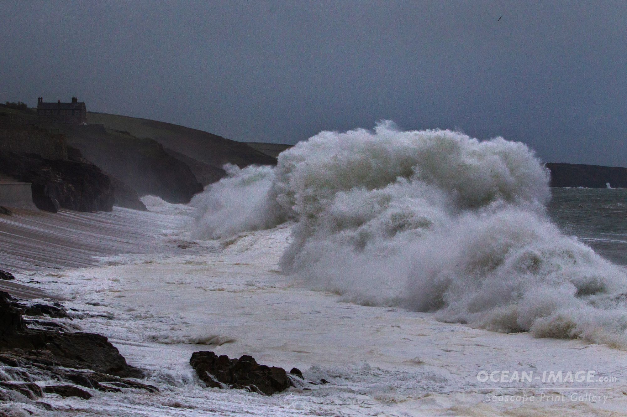 Huge white water wave hits the shore