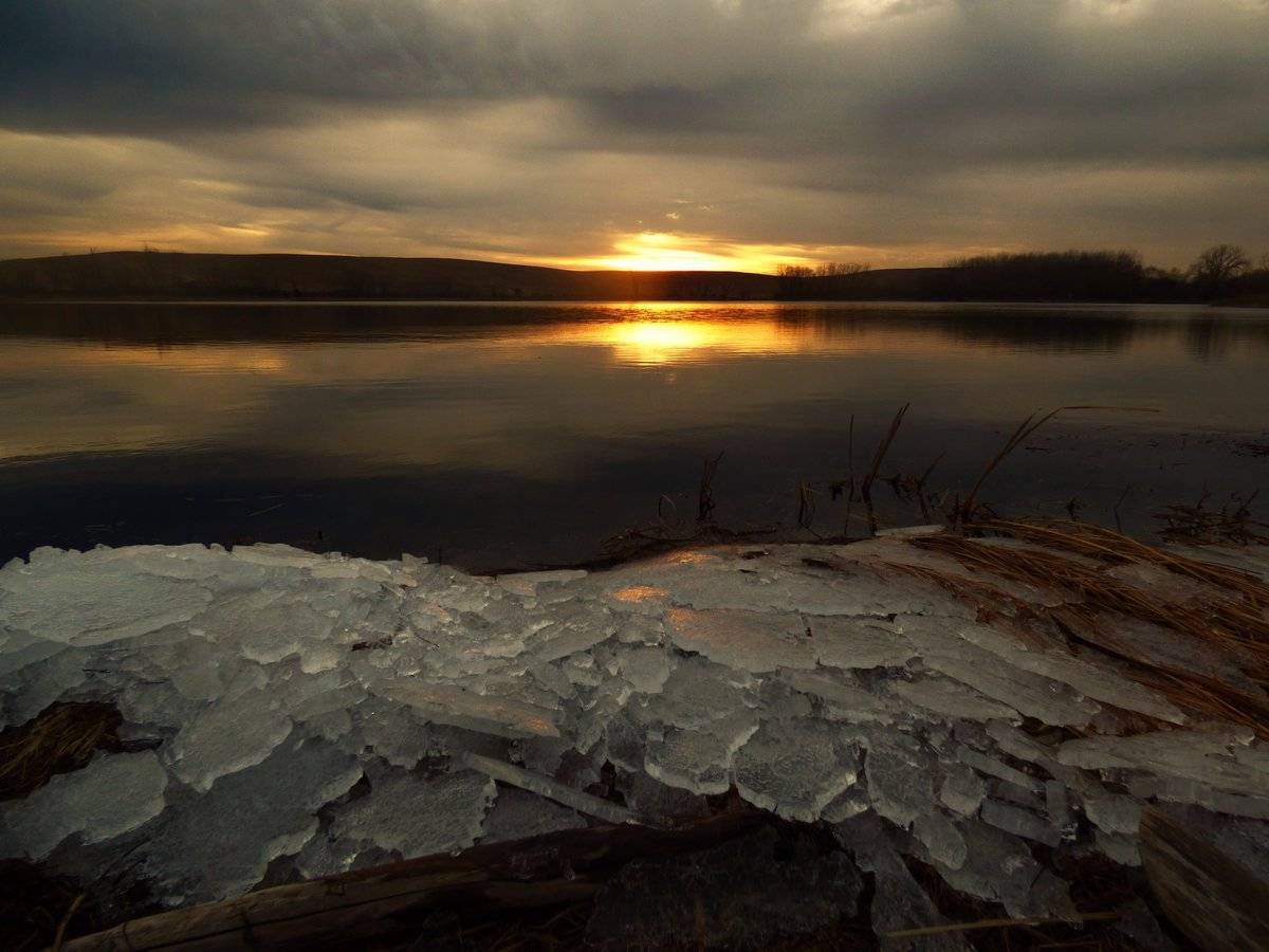 The last of the ice washes up on shore in Chicagoland at sunset