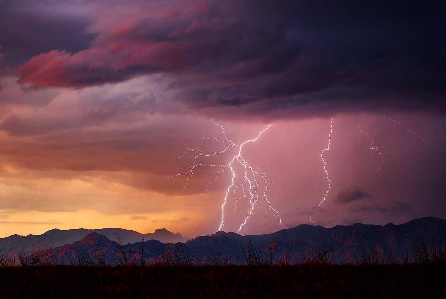 Lightning strikes in the mountains near Benson, AZ during a photogenic sunset monsoon storm by Mark J. Rebilas @rebilasphoto