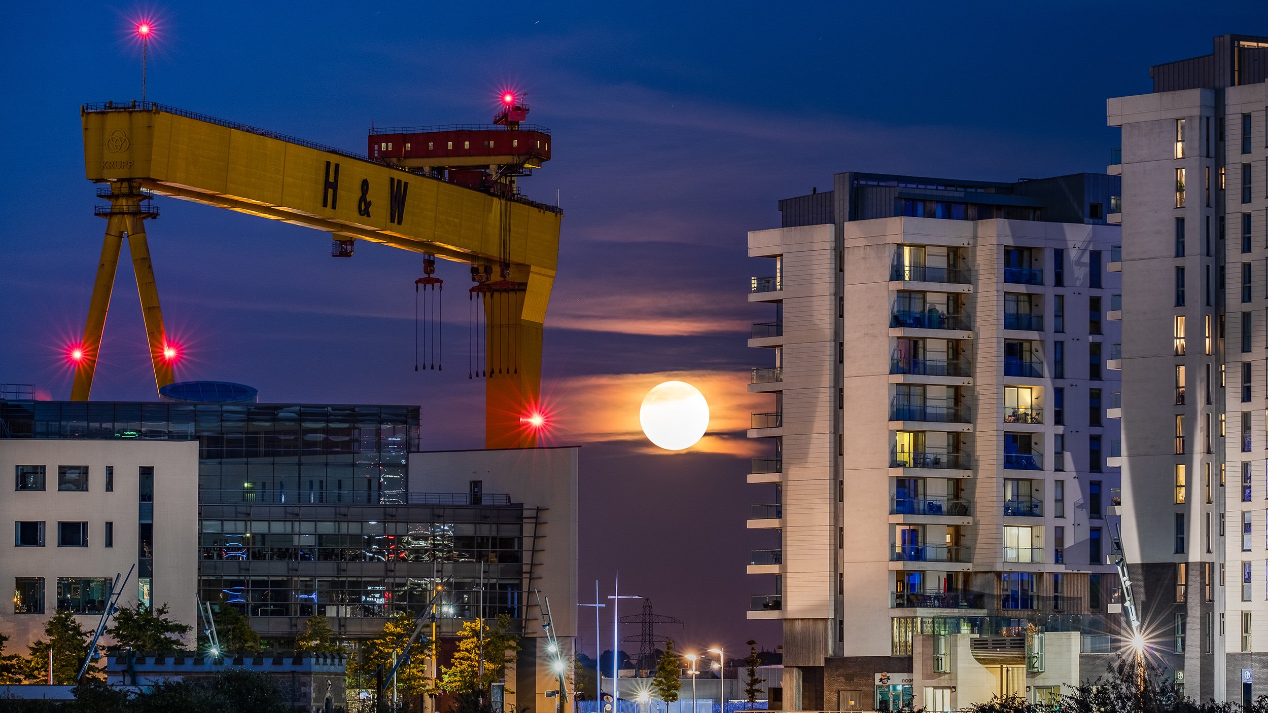 The Harvest Moon rising next to Harland & Wolff's Goliath at Titanic Quarter Belfast by Stephen Henderson @Social_Stephen